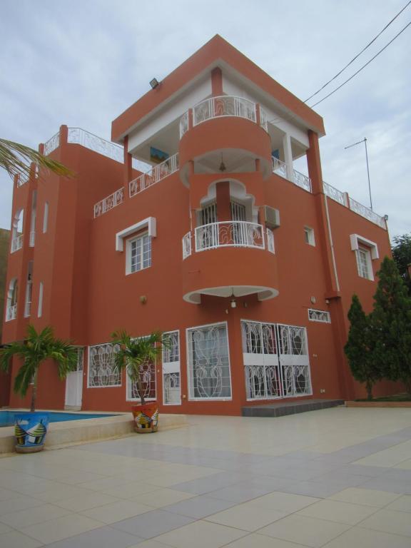 a large orange building with a balcony at Résidence Kalado Saly in Saly Portudal