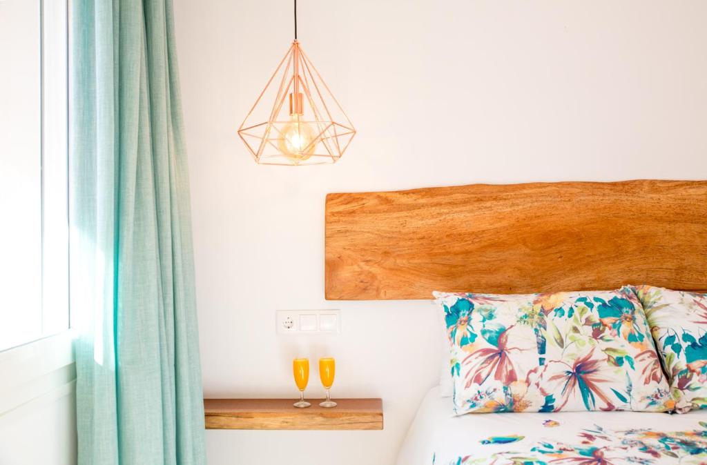a bedroom with a bed with a wooden headboard and a lamp at Fortuna in Los Caños de Meca