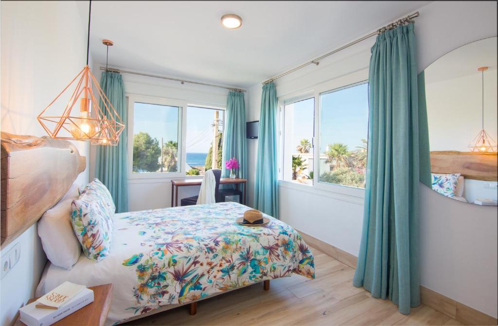 a bedroom with a bed and windows and a desk at Fortuna in Los Caños de Meca