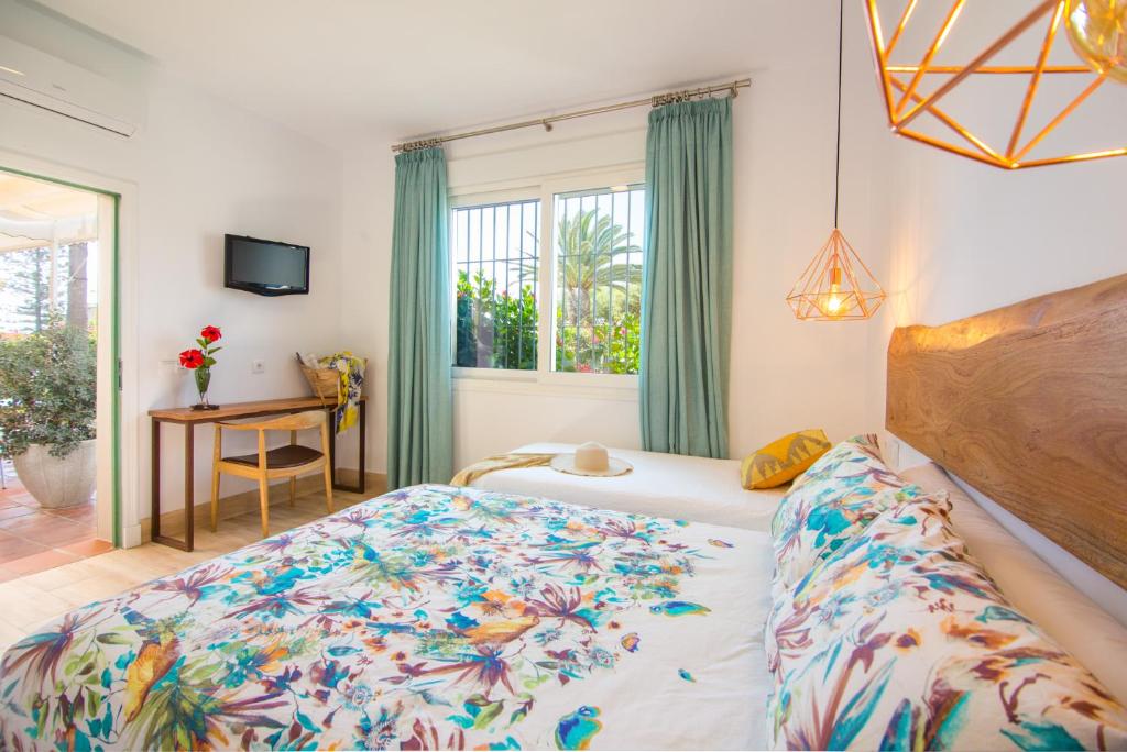 a bedroom with a bed and a desk and a window at Fortuna in Los Caños de Meca