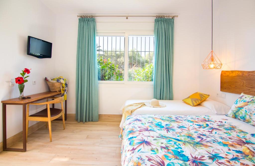 a bedroom with two beds and a desk and a window at Fortuna in Los Caños de Meca