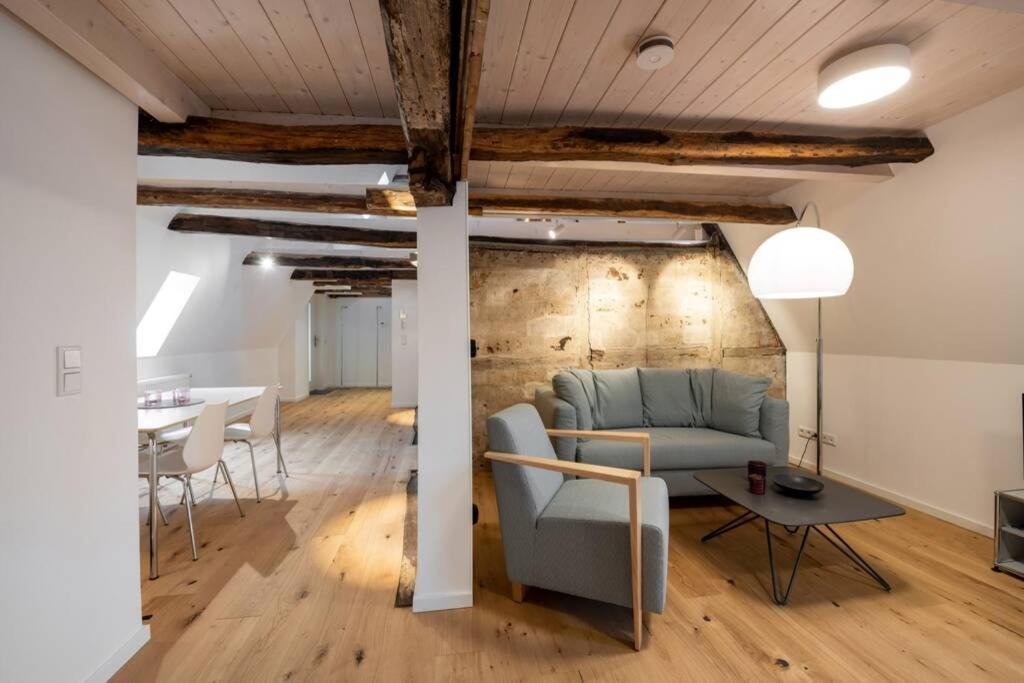 een woonkamer met een bank en een tafel bij Michaelis Suite - Schrangen-Suites-1389 in Lüneburg