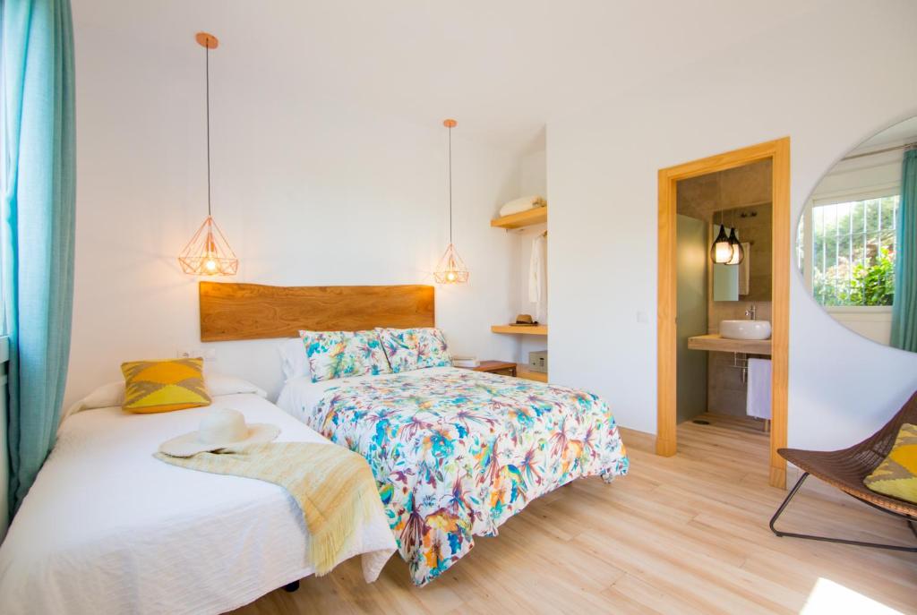 a bedroom with two beds and a chair at Fortuna in Los Caños de Meca
