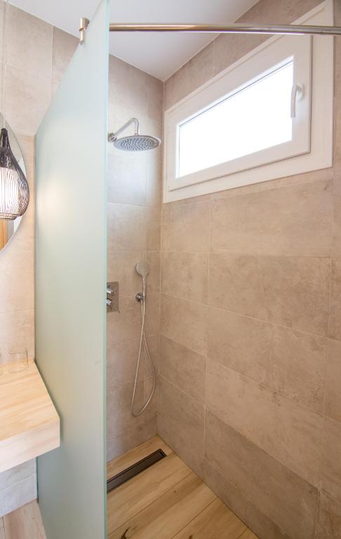 a bathroom with a shower with a window at Fortuna in Los Caños de Meca