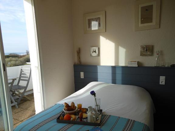 サン・ジョルジュ・ドレロンにあるHôtel de la Petite Plageの客室内のベッドにフルーツのトレイ