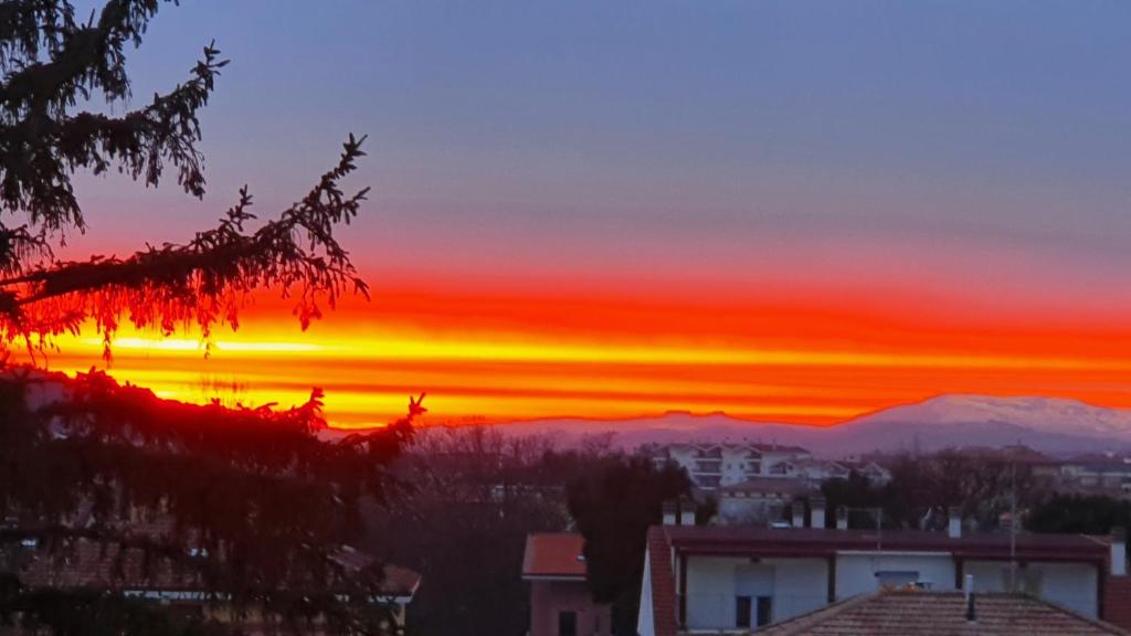 a sunset over a city with mountains in the background at Comfort House in Pesaro