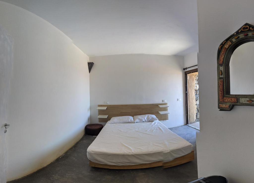 sypialnia z łóżkiem i lustrem na ścianie w obiekcie Horizon Pantelleria w mieście Pantelleria