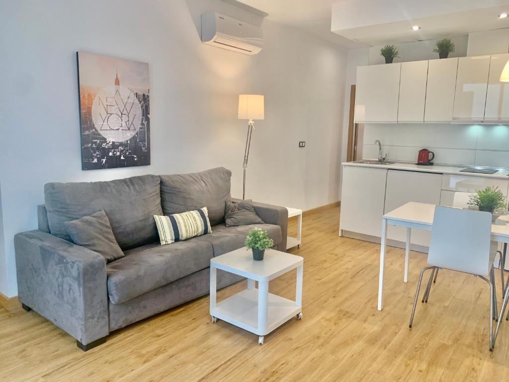 Una sala de estar con un sofá y una cocina. en Homely Málaga Refino 1-I6 y bajo E5, en Málaga