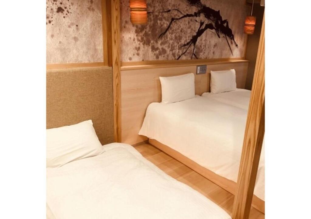 two beds in a small room with at Sakura Sky Hotel - Vacation STAY 18432v in Tokyo
