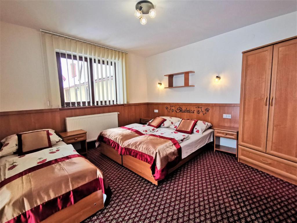 ポロニンにあるDom Gościnny Skalnicaのベッド2台とキャビネット付きのホテルルームです。