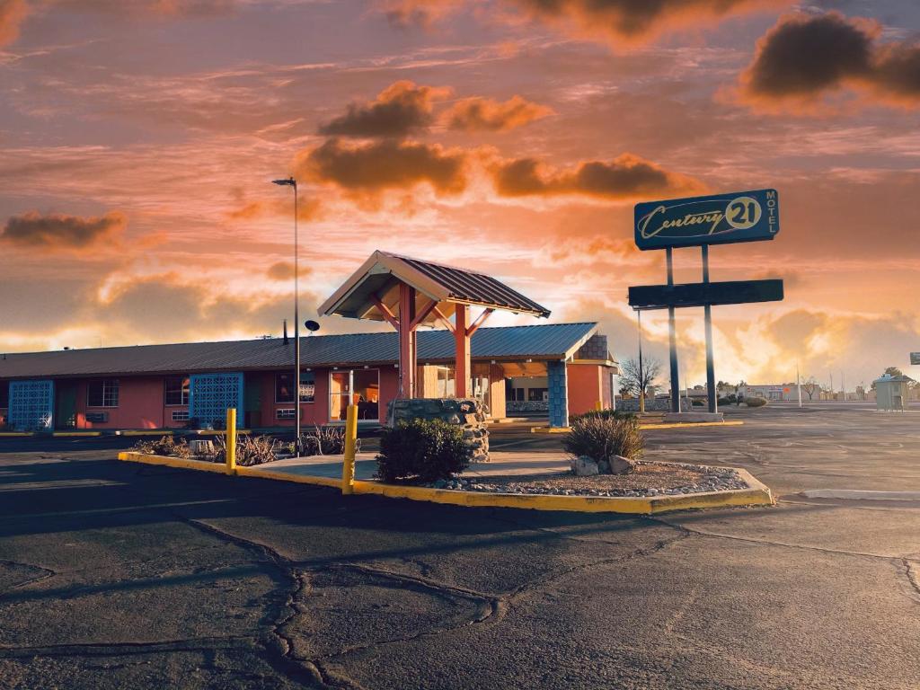 eine Tankstelle mit einem Schild auf einem Parkplatz in der Unterkunft Century 21 Motel in Las Cruces