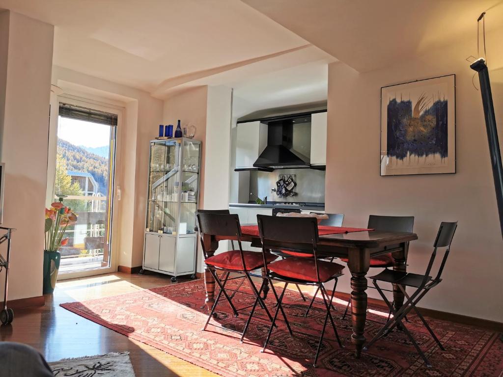 a kitchen with a table and chairs in a room at Hostdomus - Architecture Suite in Sestriere
