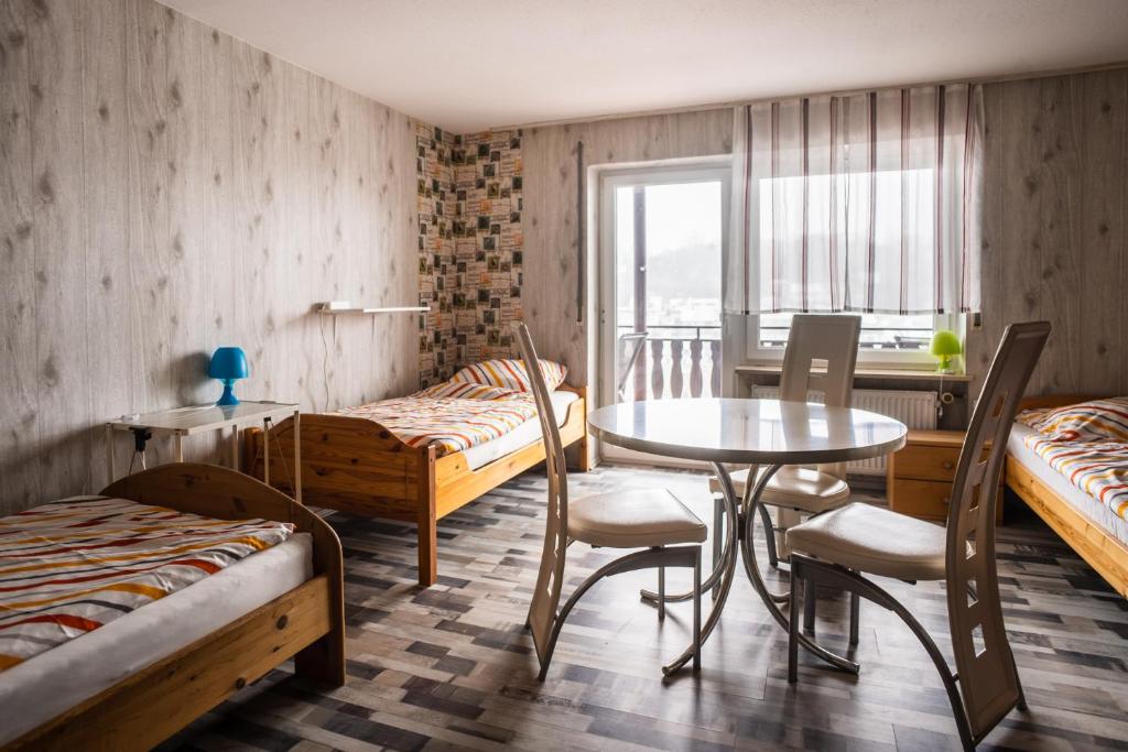 Zimmer mit 2 Betten, einem Tisch und Stühlen in der Unterkunft Monteurzimmer Rabe in Billigheim