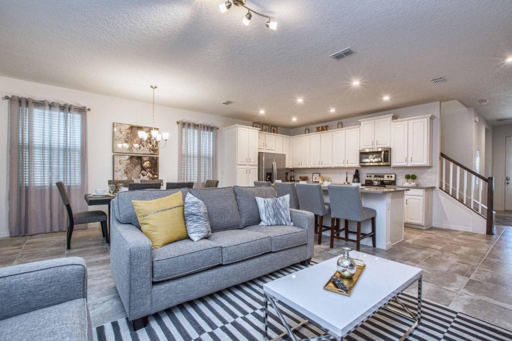 een woonkamer met een bank en een keuken bij 5 Bedrooms Townhome w- Splashpool - 8205SA in Orlando