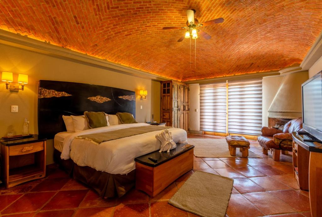 een slaapkamer met een groot bed en een plafond bij Hotel Camino de Vinos in Guanajuato