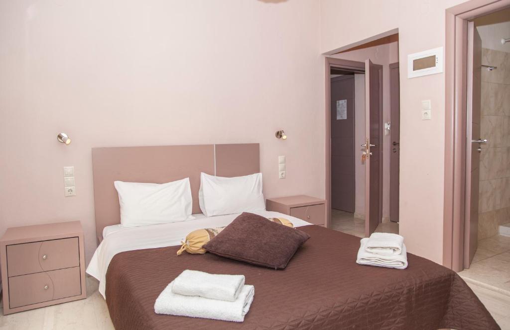 a bedroom with a large bed with two towels on it at Fantastic Matala 1 in Matala