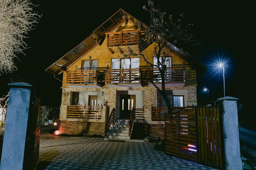 a wooden house with a gate at night at Rai pe Vale Boutique & Spa in Leordina