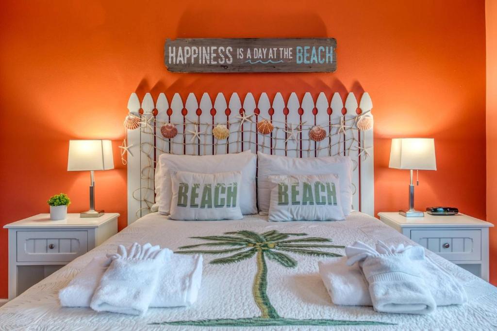 a bedroom with a bed with an orange wall at Driftwood Escape in Butler Beach