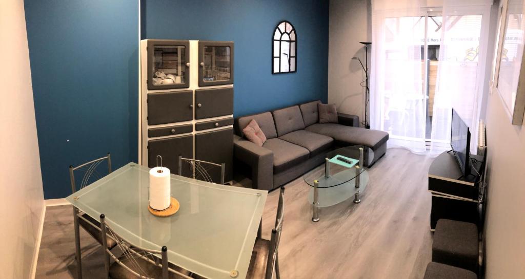 ein Wohnzimmer mit einem Sofa und einem Tisch in der Unterkunft LE DRAKKAR - 1 chambre - 4 personnes - Proximité de la plage in Saint Martin de Brehal