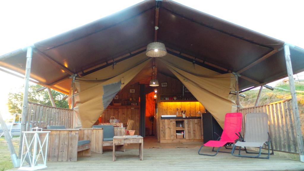 Zelt mit 2 Stühlen und einem Tisch in der Unterkunft Retour Au Source in Monprimblanc
