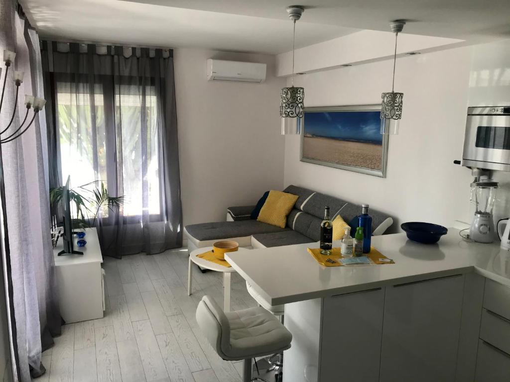 eine Küche und ein Wohnzimmer mit einem Sofa und einem Tisch in der Unterkunft CASA ROSA in Costa Teguise