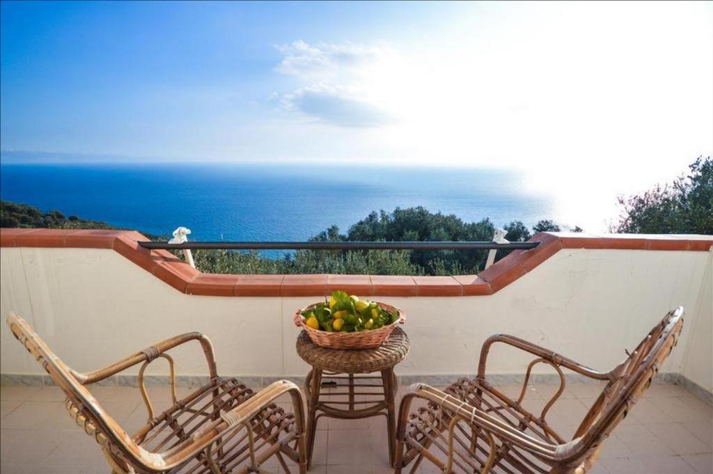 two chairs and a basket of fruit on a balcony at La Villa del Pixus in Pisciotta