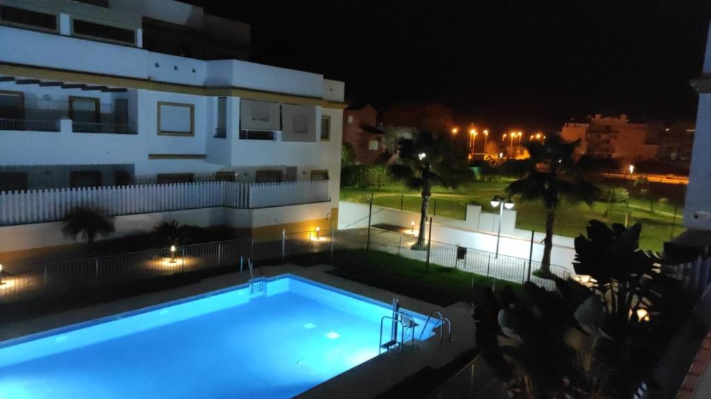 una piscina frente a un edificio por la noche en Dunas de punta candor, en Rota