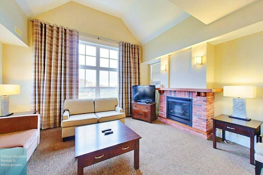 uma sala de estar com um sofá e uma lareira em Spacious Blue Mountain 2 Storey - Wifi, Pool, Close to the Village & Golf em Blue Mountains
