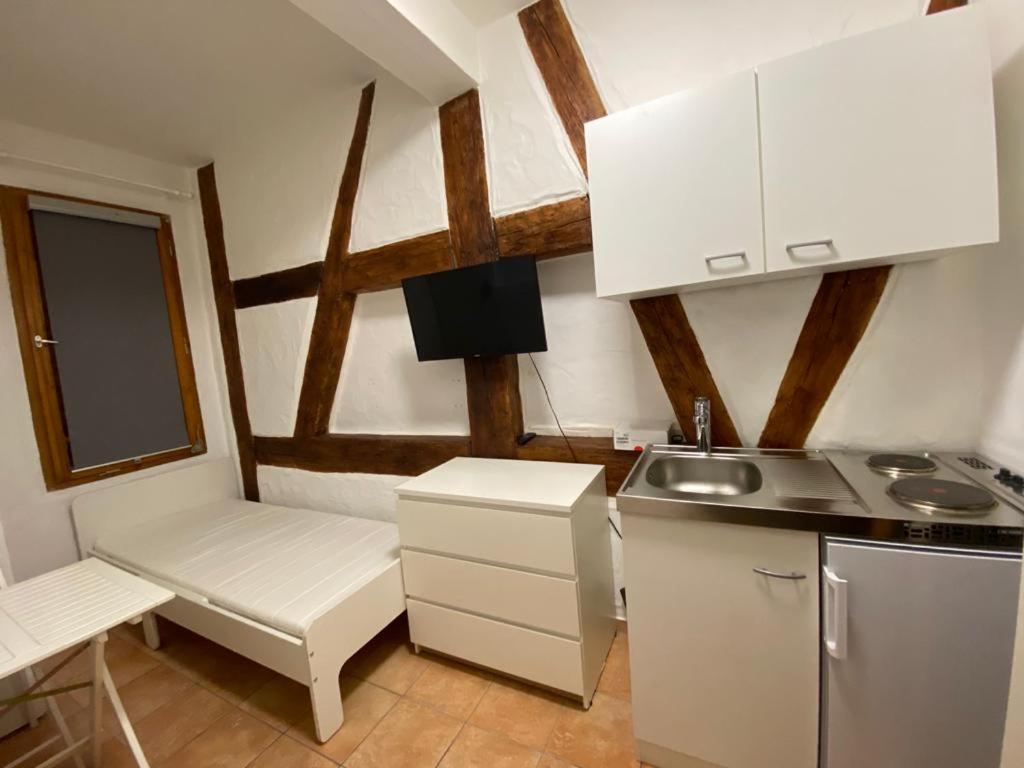 eine kleine Küche mit einem Waschbecken und einem Tisch in der Unterkunft Apartment nahe Unikliniken in Erlangen