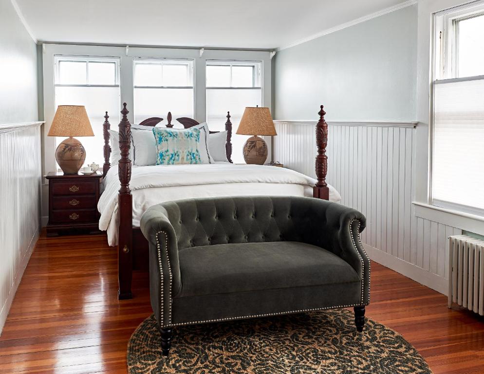 um quarto com uma cama e uma cadeira em Cliff Lodge em Nantucket