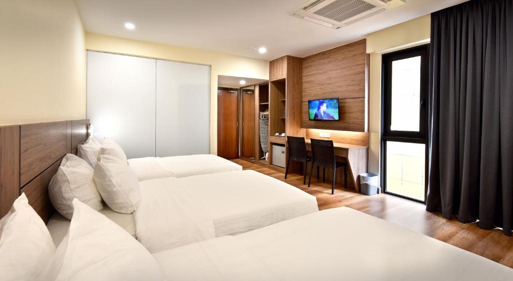 a hotel room with two beds and a desk at YANGTZE HOTEL 长江酒店 in Johor Bahru