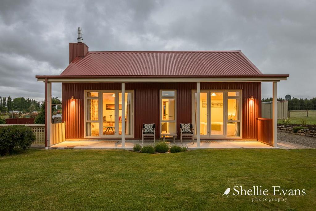 a small house with a large glass door at Night Sky Cottages - Kea Cottage - LUXURY in Twizel