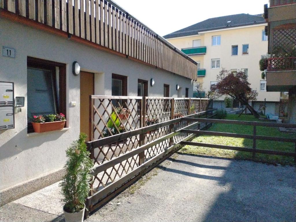 einen Zaun neben einem Gebäude mit einer Veranda in der Unterkunft Peters Guest House in Bozen