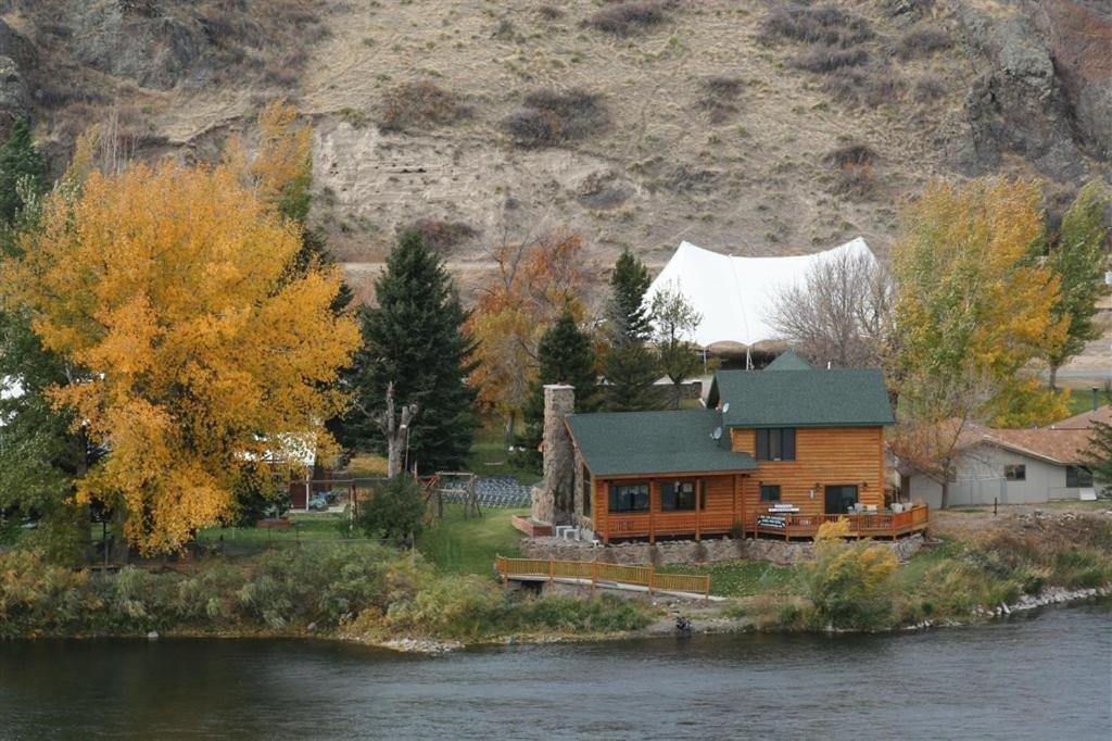 a wooden house on the side of a river at River's Bend Lodge in Cascade