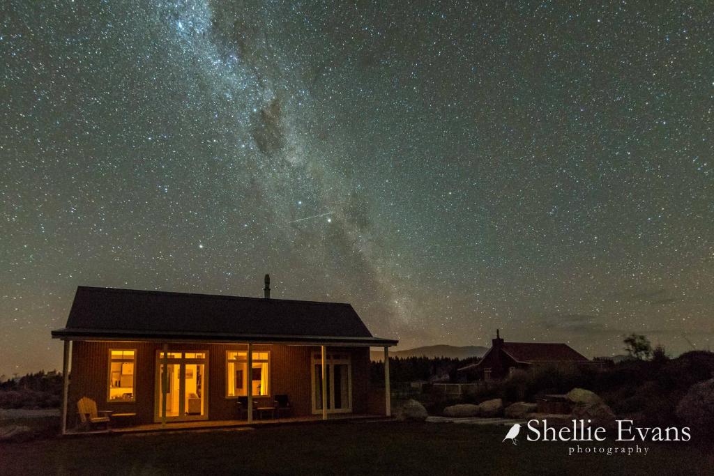 a small house under a starry sky at night at Night Sky Cottage - Kahu Cottage - HOT TUB in Twizel