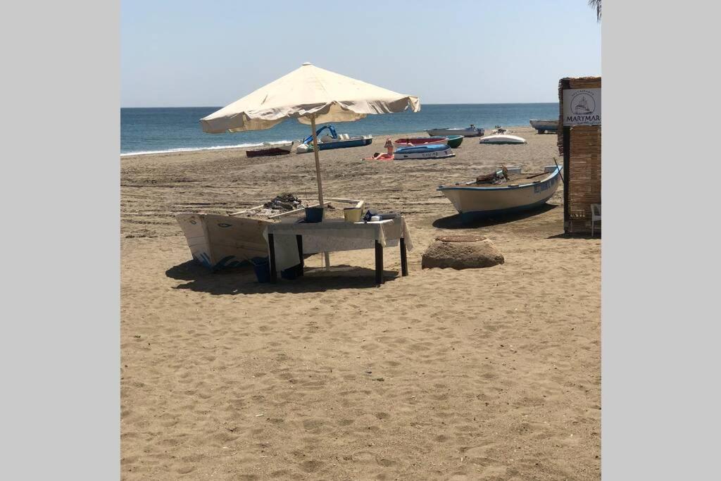 - une table et un parasol sur une plage dans l'établissement Villa Matilde Modern 2 Bedroom Apartment Close to Beach, à San Luis de Sabinillas