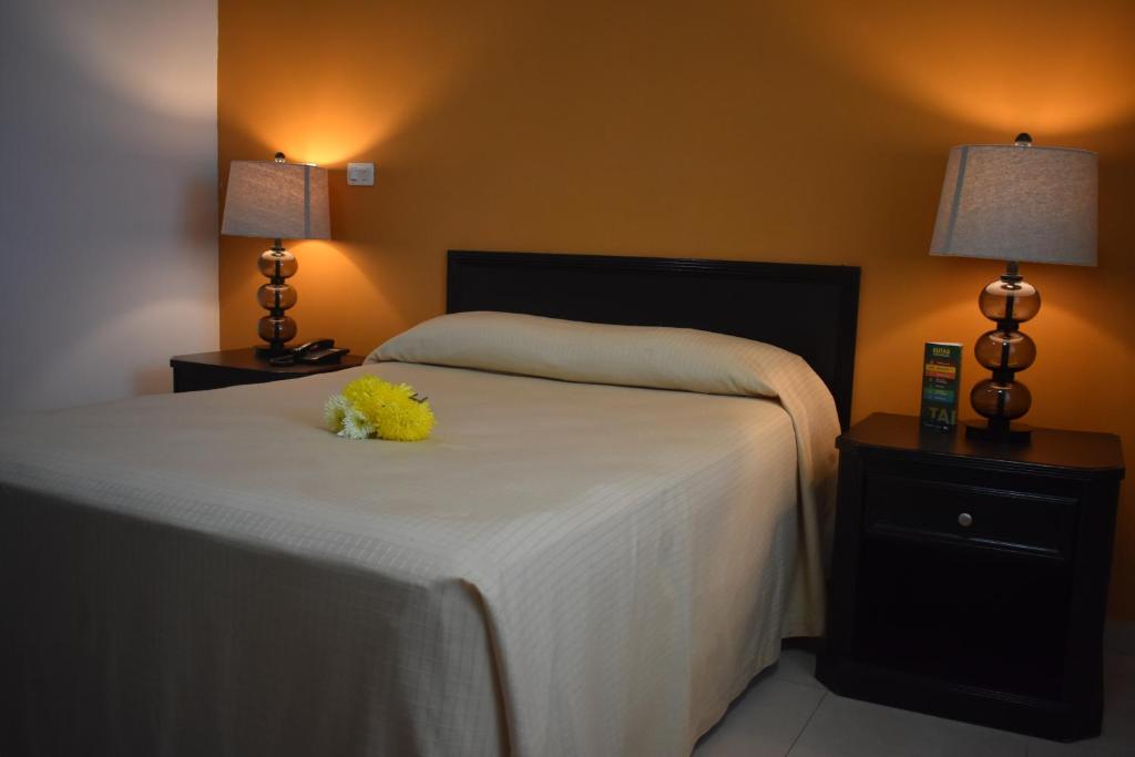 a bedroom with a bed with a yellow flower on it at Hotel Miraflores Villahermosa in Villahermosa