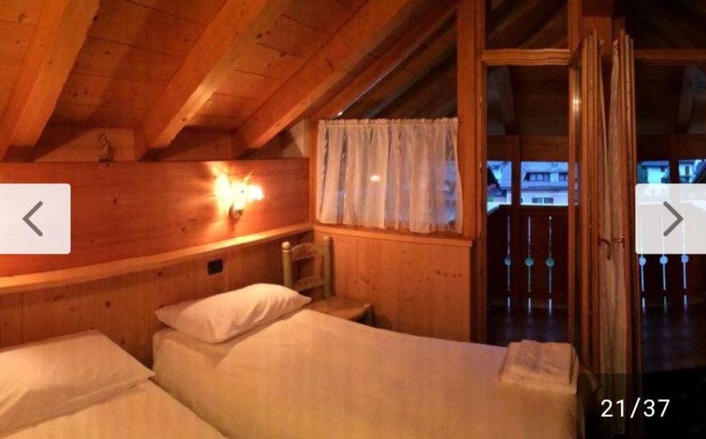a bedroom with two beds in a wooden room at Locanda Rondolost in Cencenighe