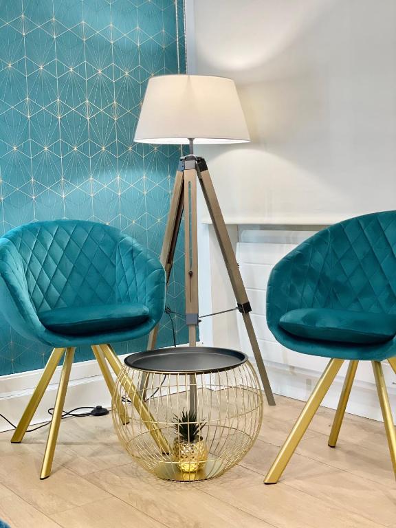 2 chaises et une table avec une lampe dans l'établissement Appart' Weekly Quartier Impérial Gare, à Metz