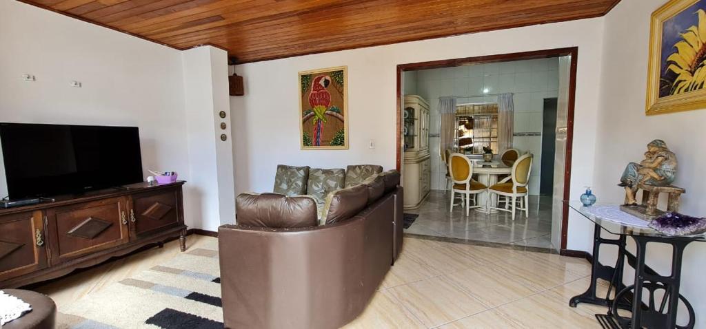 a living room with a couch and a flat screen tv at Casa Ouro Preto in Ouro Preto