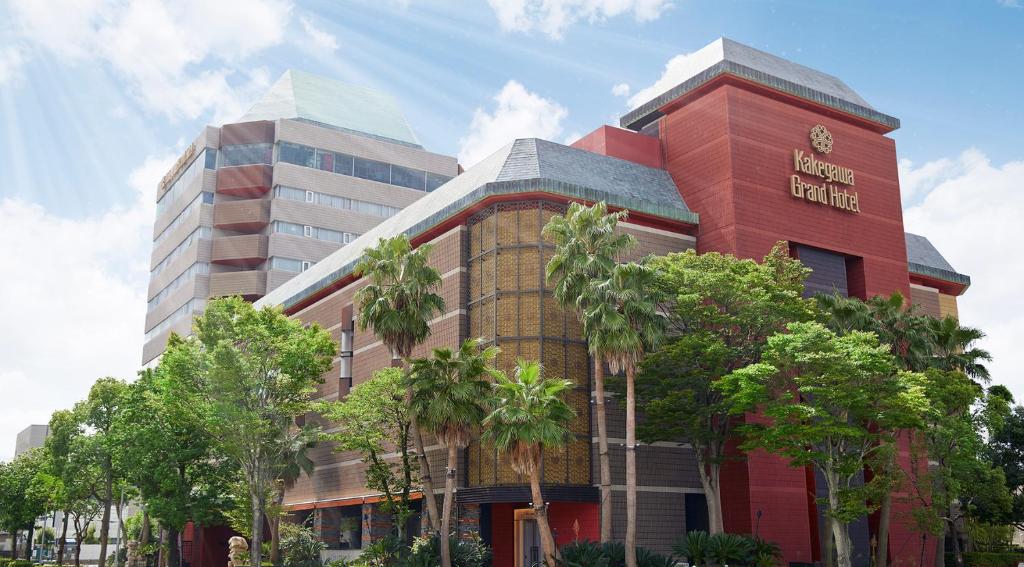 un edificio con palmeras delante en Kakegawa Grand Hotel en Kakegawa