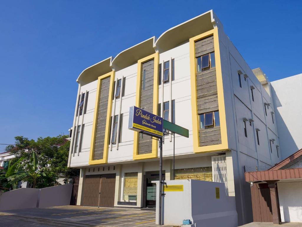 un edificio con una señal de calle delante en Pondok Indah Guest House by ecommerceloka, en Samarinda