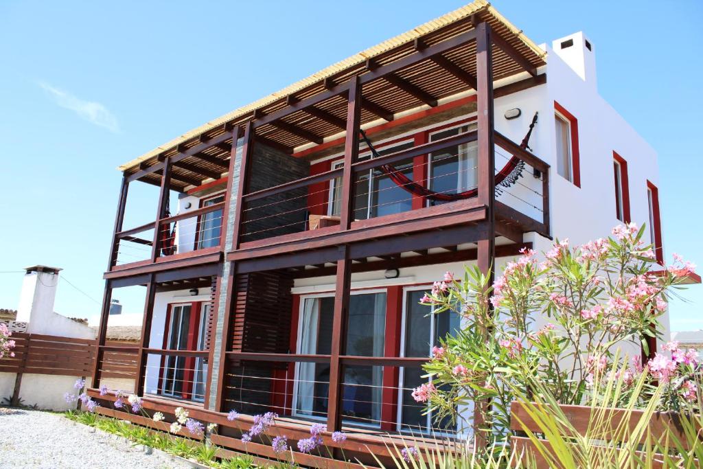 una casa con un balcón en el lateral. en Koe Porá, en Punta del Diablo