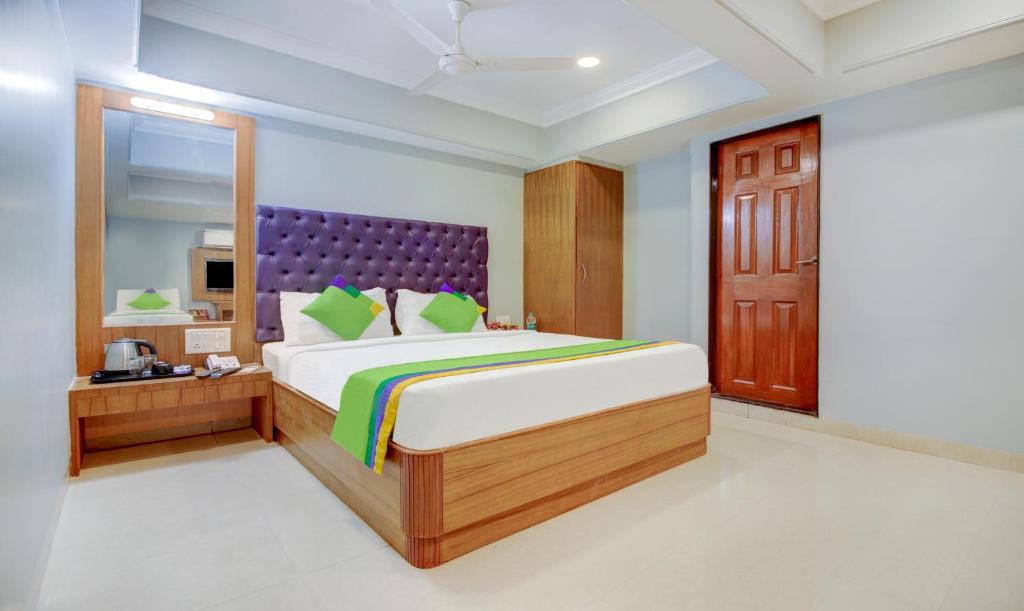 a bedroom with a large bed and a mirror at Itsy By Treebo - Cruz Royale Santacruz West in Mumbai