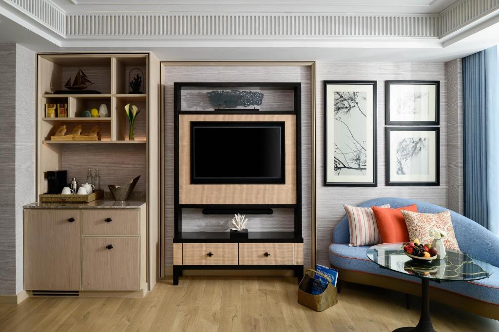 a living room with a blue couch and a tv at InterContinental Phuket Resort by IHG in Kamala Beach