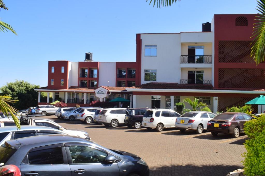 a parking lot with cars parked in front of buildings at Meru Slopes Hotel in Meru