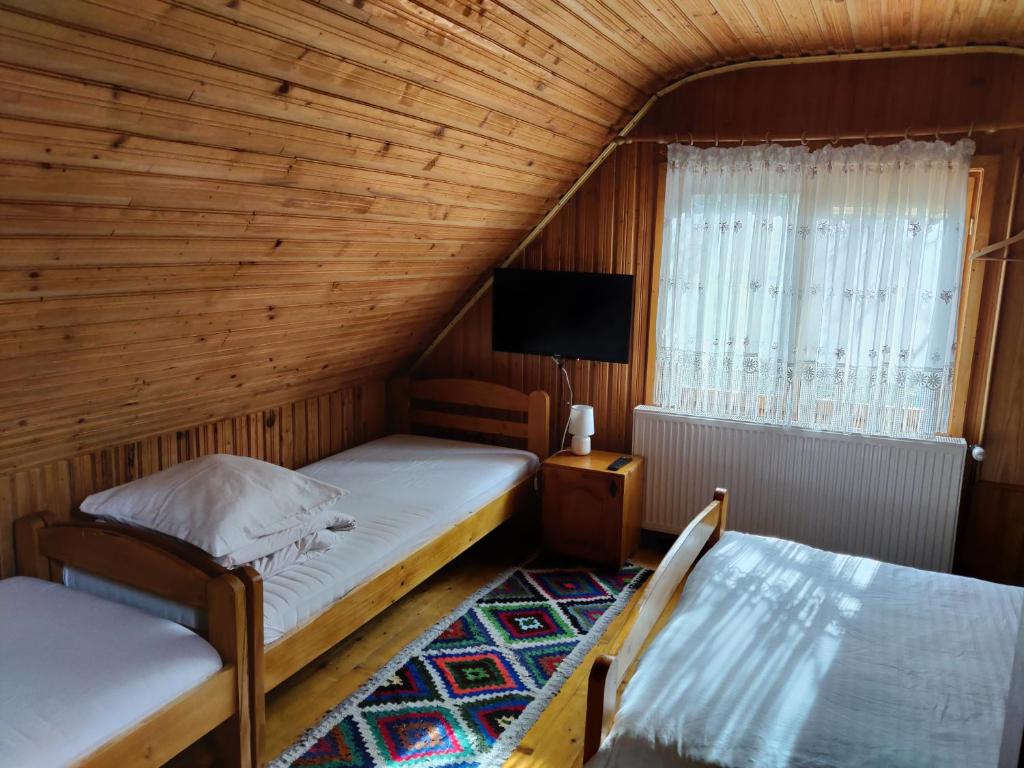 A bed or beds in a room at Pensiunea Ioana