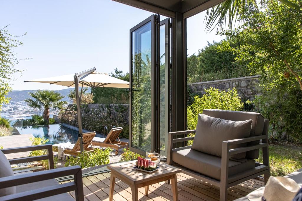 a patio with chairs and a table on a deck at METT Hotel & Beach Resort Bodrum in Bodrum City