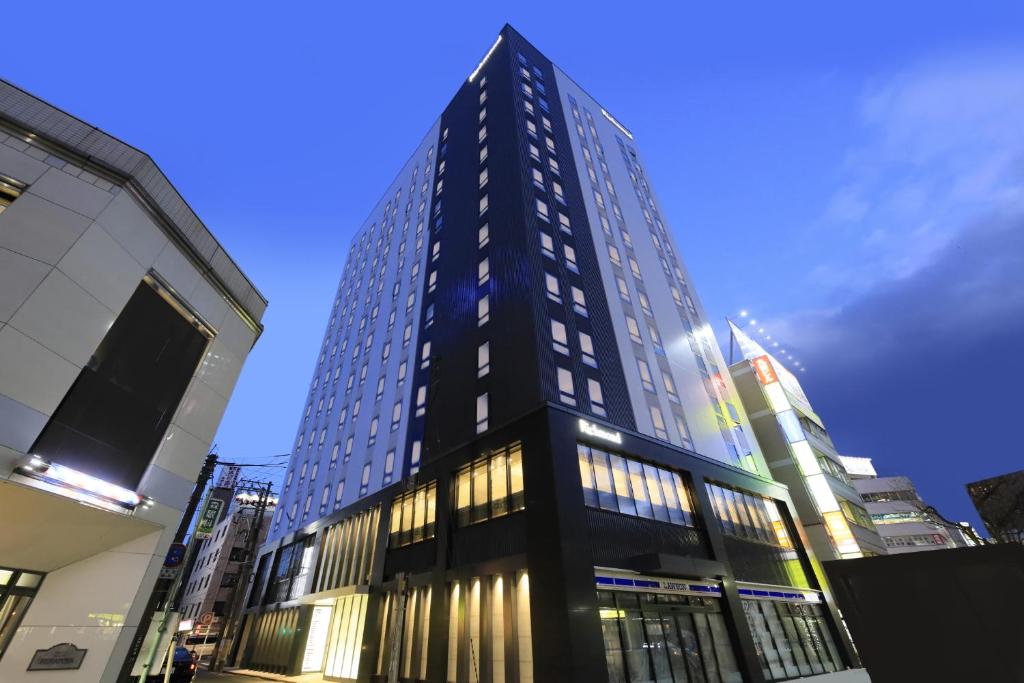 een hoog zwart gebouw met ramen in een stad bij Richmond Hotel Morioka Ekimae in Morioka