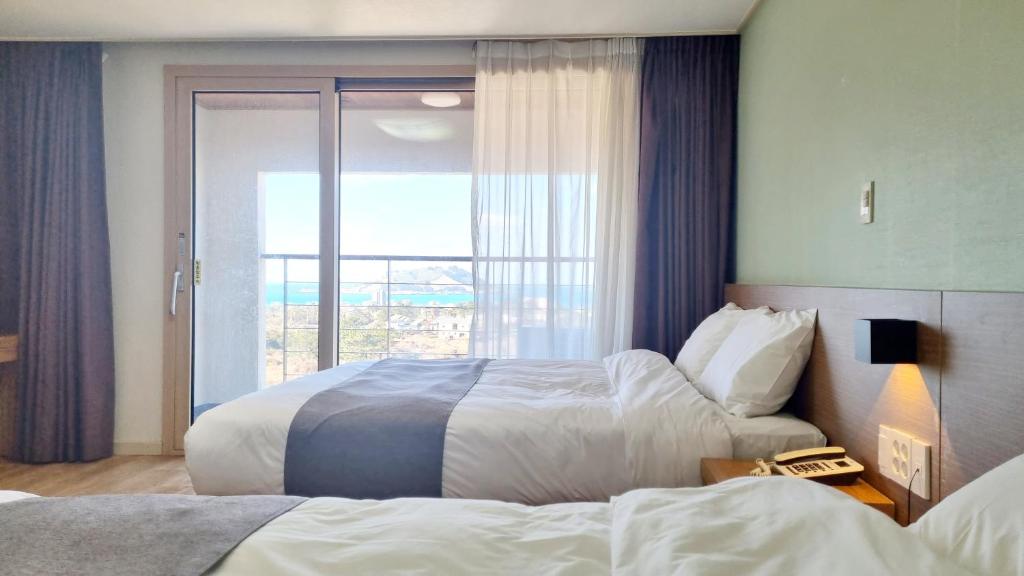 Postel nebo postele na pokoji v ubytování Hi Jeju Hotel
